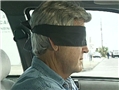 A driver wearing a blindfold to illustrate the potential hazards of the blindfold effect